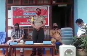 Dampingi pembagian BLT di desa, Aipda Edwin Salu himbau warga terkait Pencegahan Covid-19.