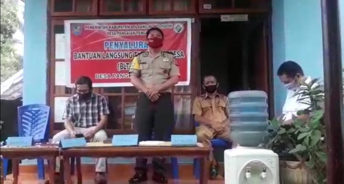 Dampingi pembagian BLT di desa, Aipda Edwin Salu himbau warga terkait Pencegahan Covid-19.