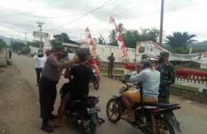 Polsek & Koramil Lolayan semakin perkuat soliditas dengan bersama-sama bagikan masker di jalan.