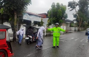 Totalitas Penuh, Kanit Lantas Polsek Kotamobagu Laksanakan Pengaturan Arus Lalin Dibawah Guyuran Hujan