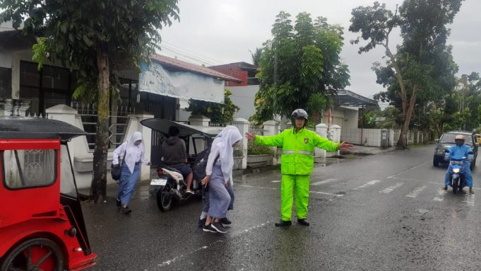 Totalitas Penuh, Kanit Lantas Polsek Kotamobagu Laksanakan Pengaturan Arus Lalin Dibawah Guyuran Hujan