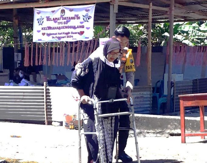 Selain Berfokus Pada Pengamanan, Personil PAM TPS Bripda Paskal Sumendap Aktif Layani Lansia Tunaikan Hak Pilihnya