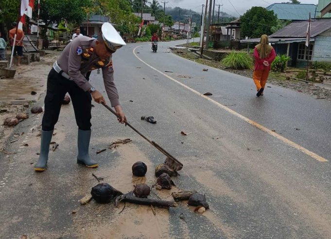 Terganggu Beberapa Menit Akibat Luapan Air, Personil Polres Kotamobagu Bersihkan Material Banjir yang Sempat Memutus Akses Jalan