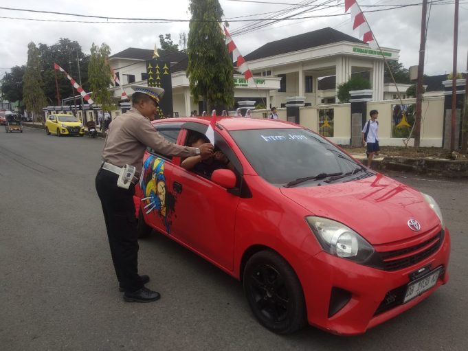 Sat Lantas Polres Kotamobagu Gelar Aksi “Polantas Menyapa” dengan Bagikan Bendera Merah Putih